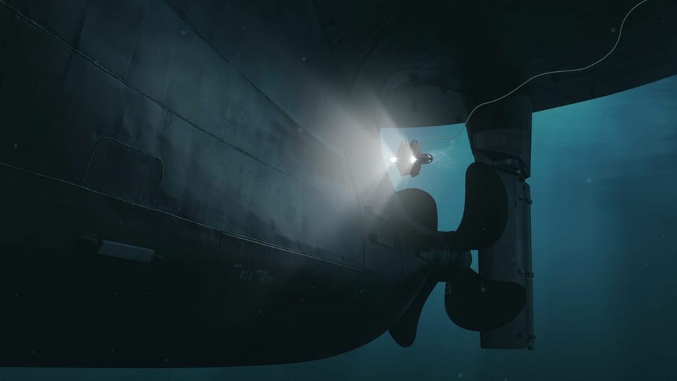 Underwater inspection ROV with lights surveying a ship's propeller and rudder