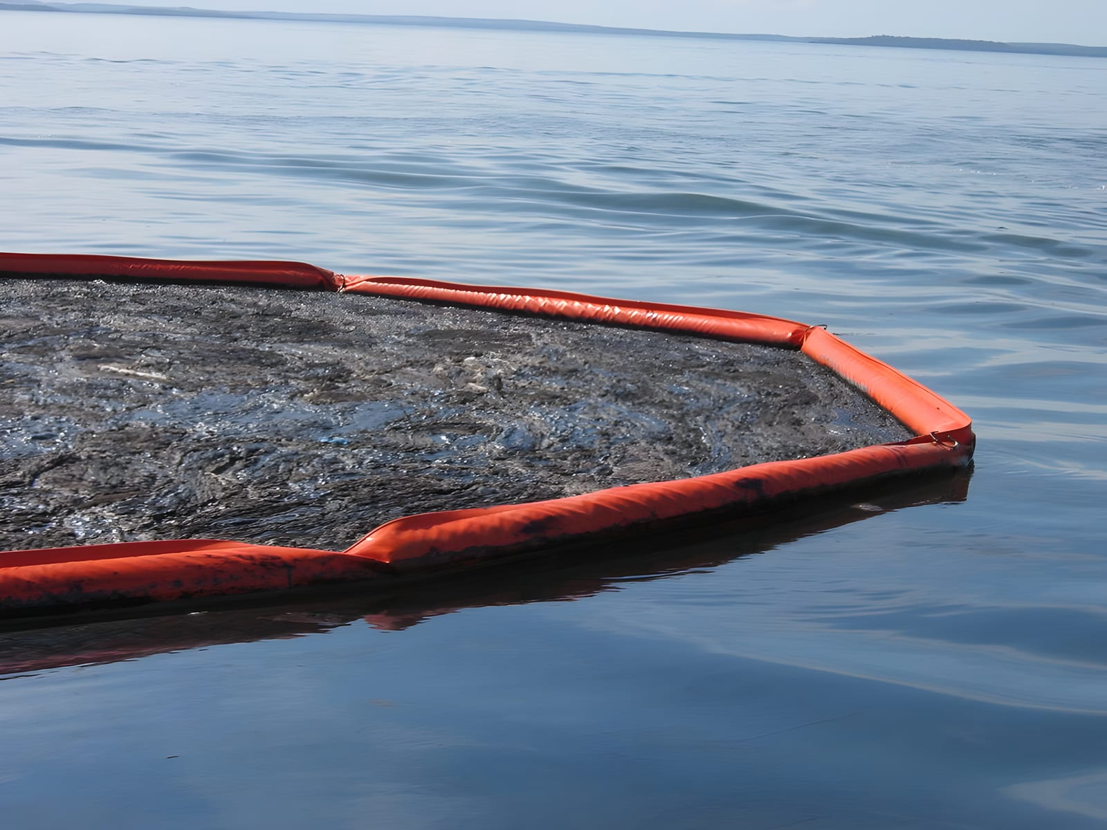 Floating containment boom deployed across the water