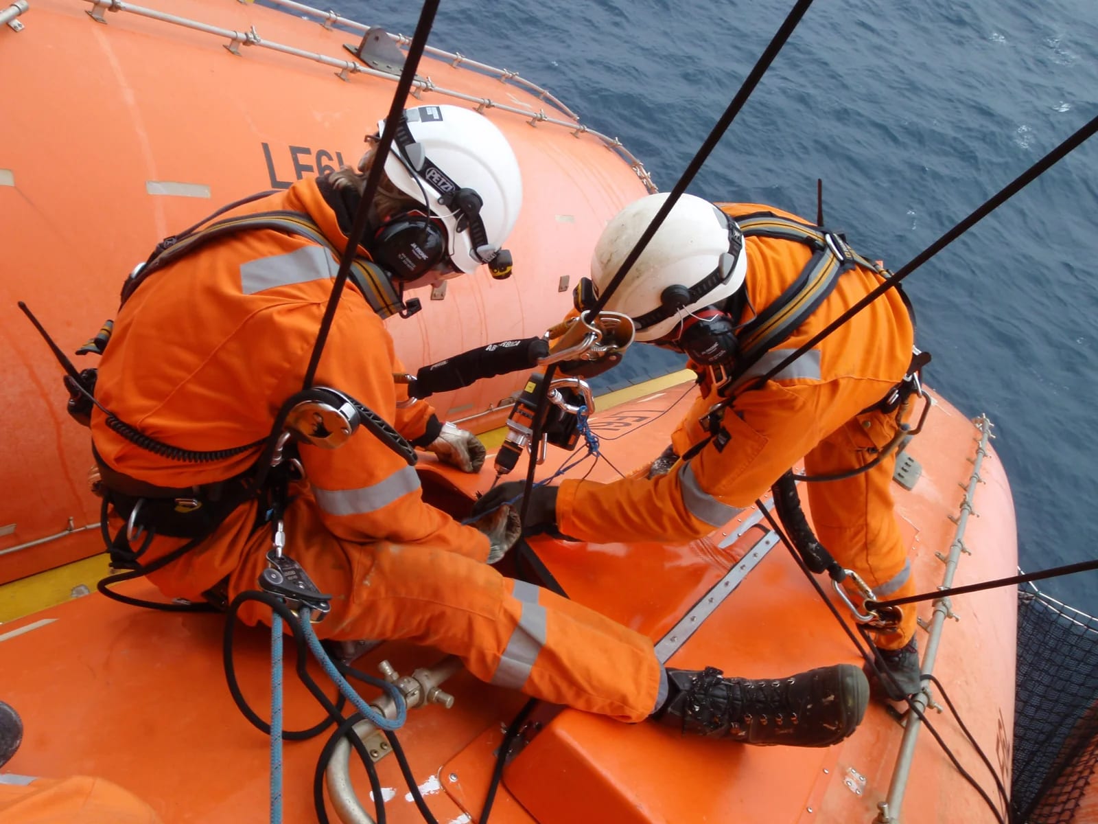 Service technicians working on a lifeboat during scheduled maintenance